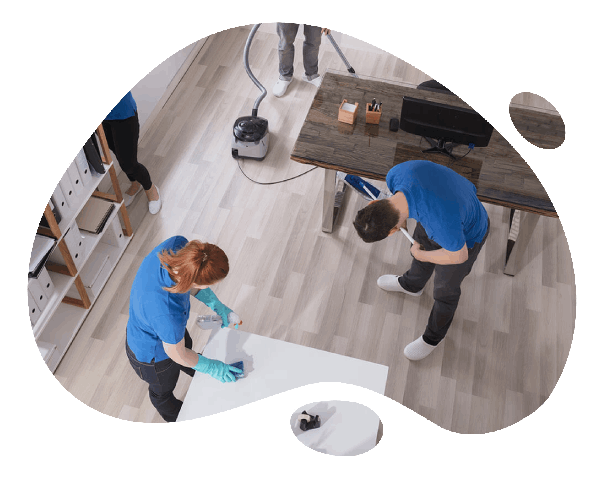 Professional team providing top-quality cleaning services in Melbourne, sanitizing office desks and vacuuming floors.