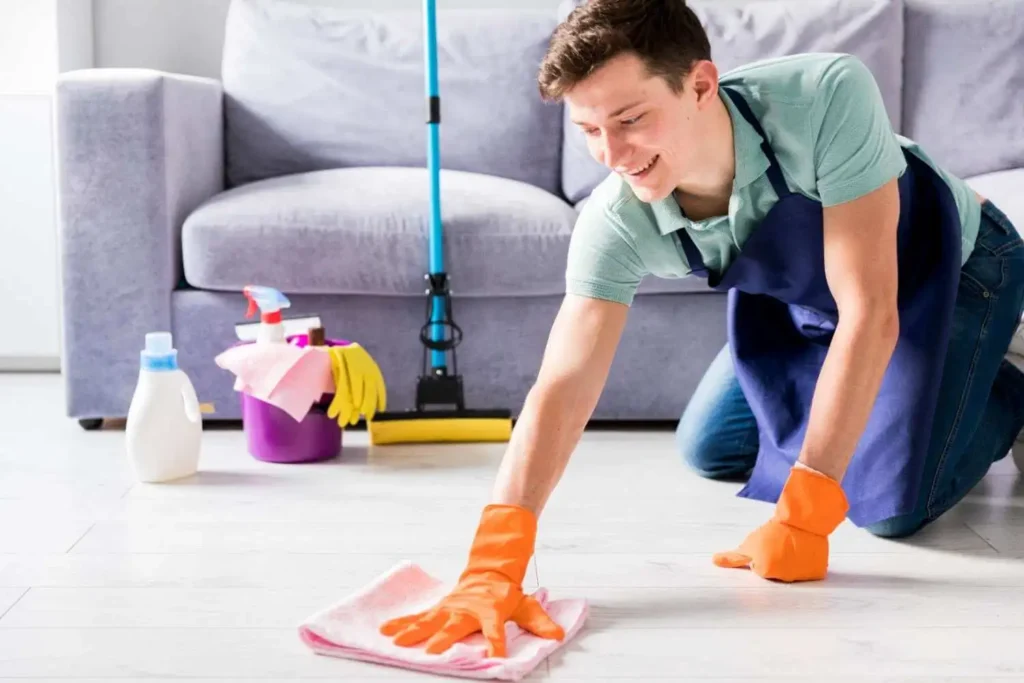 Male cleaner scrubbing a floor with gloves and cloth – How Clean Is Your House Before and After a Professional Service in Melbourne.